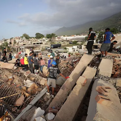 AME5030. LA GUAIRA (VENEZUELA), 26/06/2026.- Personas realizan labores de búsqueda en una zona afectada por un terremoto, este viernes en La Guaira (Venezuela). Venezuela afrontó su tercer día de emergencia con apoyo de brigadas de rescate de nueve países, entre ellos Estados Unidos y España, que se han sumado a las labores de búsqueda de supervivientes o fallecidos, tras el doble terremoto del pasado miércoles que deja al menos 920 muertos y 3.360 heridos, según cifras oficiales. EFE/ Ronald Peña R
