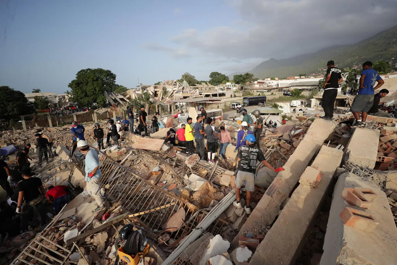 AME5030. LA GUAIRA (VENEZUELA), 26/06/2026.- Personas realizan labores de búsqueda en una zona afectada por un terremoto, este viernes en La Guaira (Venezuela). Venezuela afrontó su tercer día de emergencia con apoyo de brigadas de rescate de nueve países, entre ellos Estados Unidos y España, que se han sumado a las labores de búsqueda de supervivientes o fallecidos, tras el doble terremoto del pasado miércoles que deja al menos 920 muertos y 3.360 heridos, según cifras oficiales. EFE/ Ronald Peña R
