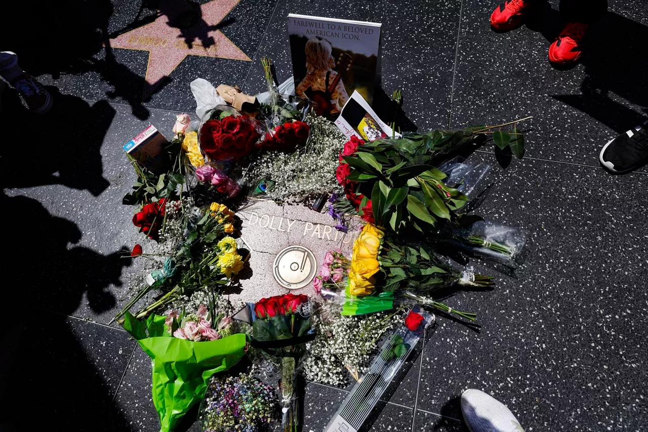 FOTODELDÍA EPA4465. LOS ANGELES (ESTADOS UNIDOS), 25/08/2026.- Fotografía que muestra flores y objetos en la estrella del Paseo de la Fama de Hollywood de la cantante y actriz Dolly Parton tras su fallecimiento este martes, en Hollywood, (Estados Unidos). EFE/EPA/ Chris Torres
