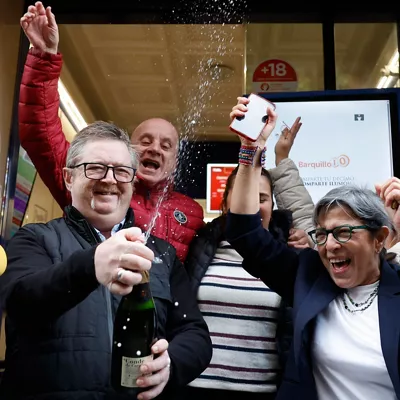 MADRID, 22/12/2025.-Varias personas celebran a las puertas de la administración de loterías del número 10 de la calle Barquillo, en Madrid, donde se ha vendido íntegramente el 70.048, el segundo premio del Sorteo Extraordinario de la Lotería de Navidad. EFE/Mariscal
