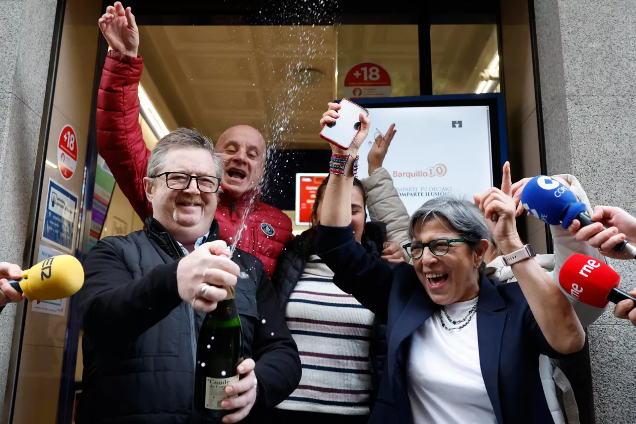 MADRID, 22/12/2025.-Varias personas celebran a las puertas de la administración de loterías del número 10 de la calle Barquillo, en Madrid, donde se ha vendido íntegramente el 70.048, el segundo premio del Sorteo Extraordinario de la Lotería de Navidad. EFE/Mariscal
