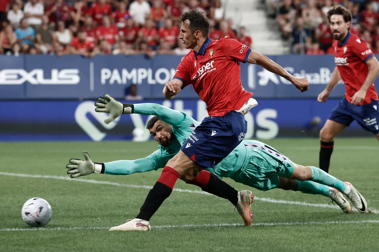 PAMPLONA, 24/08/2026.- El delantero de Osasuna Ante Budimir trata de superar al portero Mathew Ryan (detrás), del Levante, durante el partido de LaLiga EA Sports que CA Osasuna y Levante UD disputan este lunes en el estadio de El Sadar, en Pamplona. EFE/Jesús Diges
