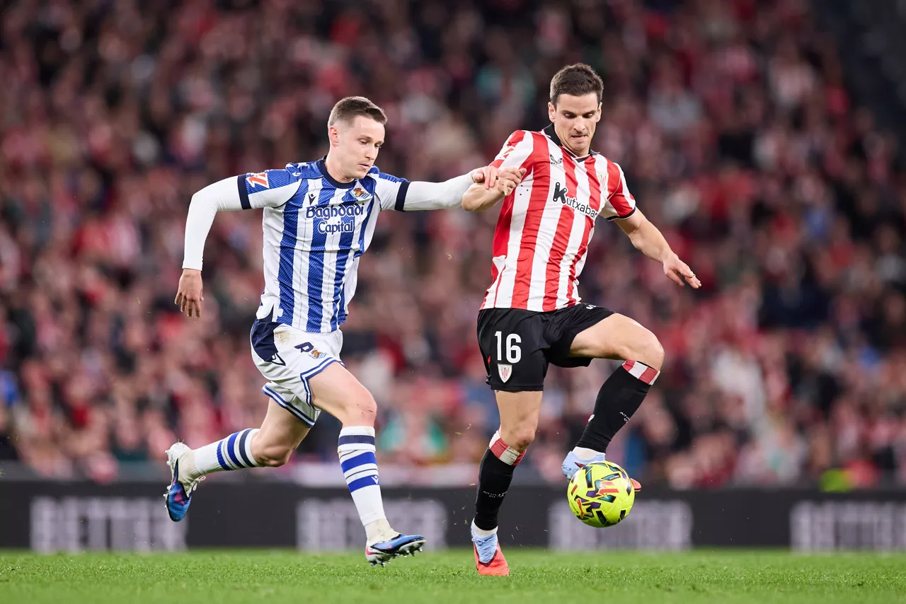 Beñat Turrientes y Iñigo Ruiz de Galarreta pugnan por un balón durante el derbi disputado entre el Athletic y la real Sociedad el 1 de febrero de 2026.