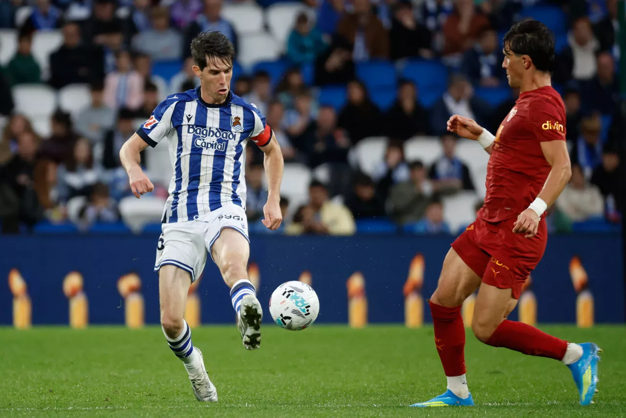 SAN SEBASTIÁN, 17/05/2026.- El defensa de la Real Aritz Elustondo (i) juega un balón ante Vázquez Alcaide, del Valencia, durante el partido de la jornada 37 de LaLiga que Real Sociedad y Valencia CF disputan este domingo en el estadio de Anoeta, en San Sebastián. EFE/Juan Herrero
