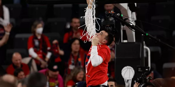 El técnico italiano de Baskonia Paolo Galbiati corta la red de una de las canastas. Foto: EFE
