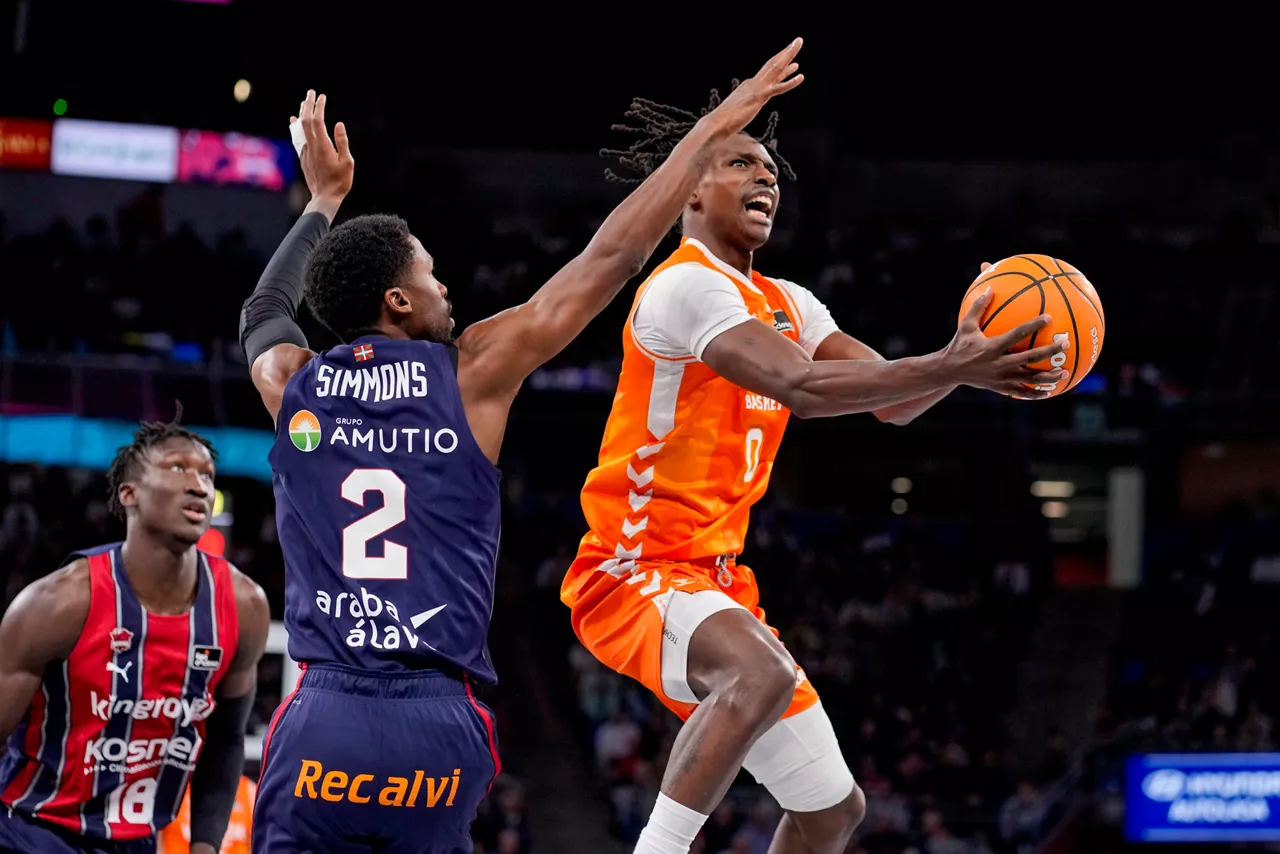 VITORIA-GASTEIZ, 07/12/2025.-El escolta del Valencia Brancou Badio (d) juega un balón ante Kobi Simmons (c), del Baskonia, durante el partido de la Liga Endesa de baloncesto que Kosner Baskonia y Valencia Basket disputan este domingo en el pabellón Fernando Buesa Arena de Vitoria. EFE/Adrián Ruiz Hierro
