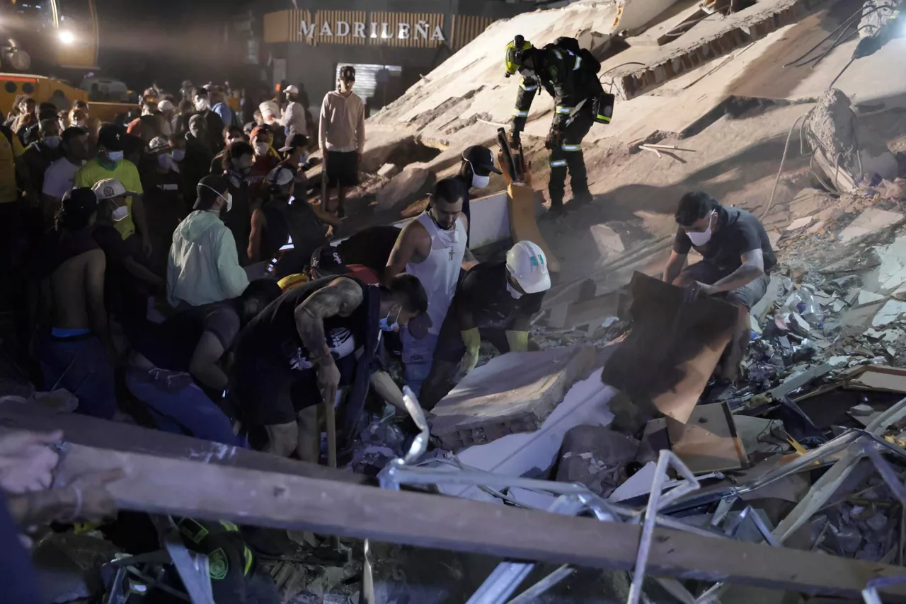 Pereira (Colombia), 11/08/2026.- Members of the Search and Rescue Police and other individuals conduct search operations in a building across from Parque la Libertad, following a 7.4-magnitude earthquake that struck the country, in Pereira, Colombia, 10 August 2026. Colombian President Abelardo de la Espriella stated that the San Jose de Palmar earthquake, which shook most of the country, has killed at least 132 people and left 572 injured. (Terremoto/sismo) EFE/EPA/CARLOS ORTEGA
