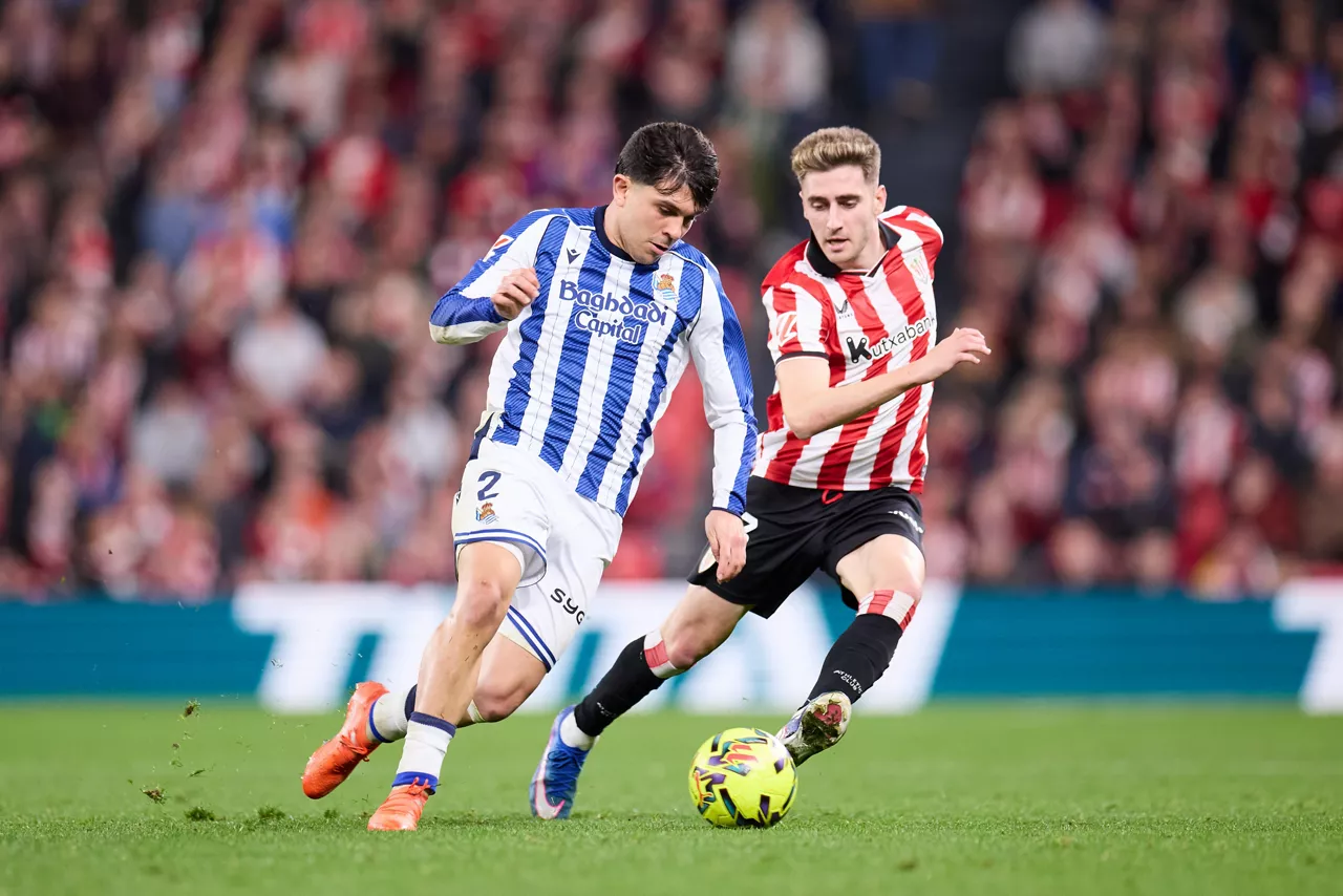 Jon Aramburu of Real Sociedad competes for the ball with Robert Navarro of Athletic Club during the LaLiga EA Sports match between Athletic Club and Real Sociedad at San Mames on February 1, 2026, in Bilbao, Spain.