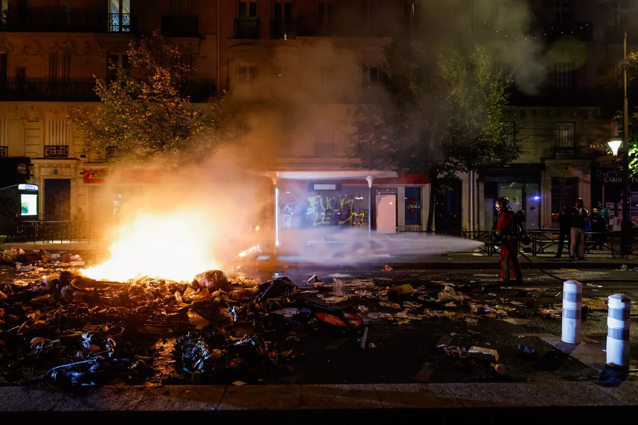 PARIS (France), 19/10/2026.- A French firefighter responds to a street barricade burns as clashes between riot police and demonstrators continue for the second day during nationwide protests against the high cost of living in Paris, France, 18 October 2026. (Protestas, Francia) EFE/EPA/MOHAMMED BADRA
