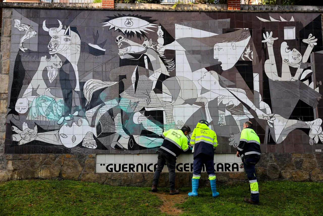 GERNIKA (BIZKAIA), 28/11/2025.-Varios operarios limpian las pintadas con las que ha amanecido vandalizado el mural del Guernica de Picasso en la localidad de Gernika (Bizkaia), que este viernes acude el presidente de la República Federal de Alemania Frank-Walter Steinmeier, el primer mandatario de Alemania en visitar la ciudad de Gernika, donde participa junto al rey Felipe VI en una ofrenda floral en memoria de las víctimas del bombardeo de esta localidad vizcaína durante la Guerra Civil. EFE/ Luis Tejido
