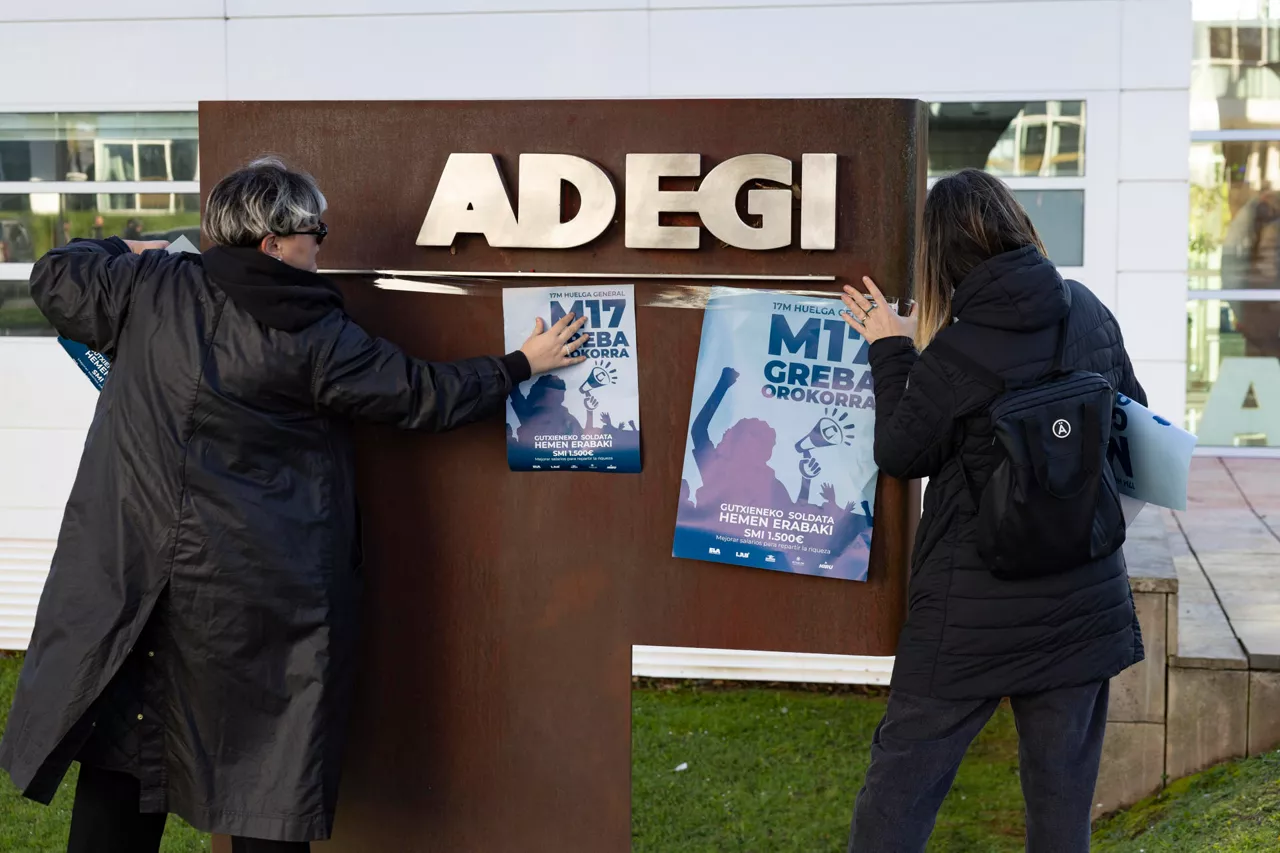 SAN SEBASTIÁN, 17/03/2026.- Un piquete informativo coloca carteles en la puerta de la patronal guipuzcoana Adegi en San Sebastián durante la huelga general convocada por ELA, LAB y otros sindicatos vascos, en demanda de un salario mínimo interprofesional (SMI) propio. EFE/ Javier Etxezarreta

