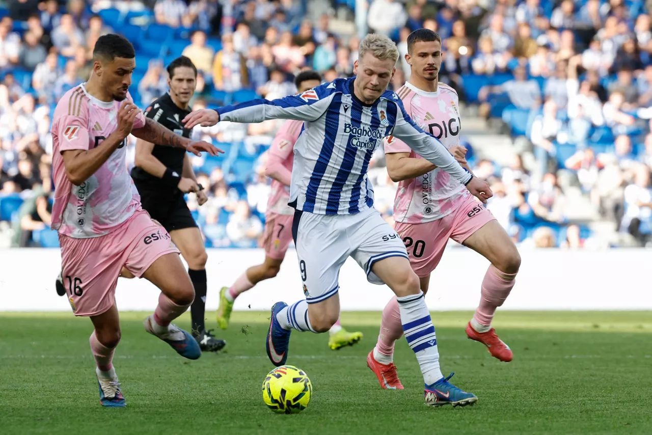SAN SEBASTIÁN, 21/02/2026.- El delantero de la Real Sociedad Orri Óskarsson (c) disputa un balón con el defensa del Oviedo David Carmo (i) durante el partido de liga que enfrentó a la Real Sociedd y el Real Oviedo en el estadio Anoeta, este sábado. EFE/Juan Herrero
