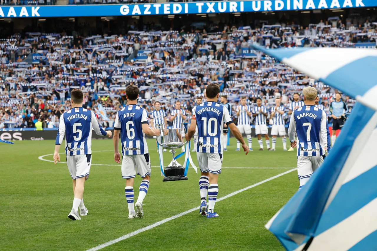 SAN SEBASTIÁN, 22/04/2026.- Los jugadores de la Real Sociedad salen al terreno de juego con el trofeo de la Copa del Rey conseguida el pasado sábdo, antes del partido de LaLiga entre la Real Sociedad y Getafe CF, este miércoles en el estadio Anoeta en San Sebastián. EFE/Juan Herrero
