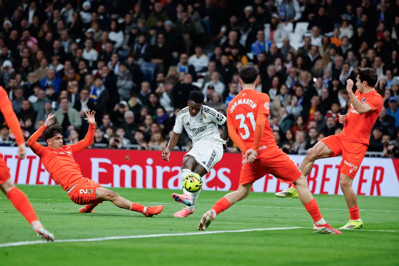 MADRID , 14/02/2026.- El delantero del Real Madrid Vinicius Jr. (c) dispara a puerta durante el partido de la jornada 24 de LaLiga entre el Real Madrid y la Real Sociedad, este sábado en el estadio Santiago Bernabéu. EFE/Sergio Pérez
