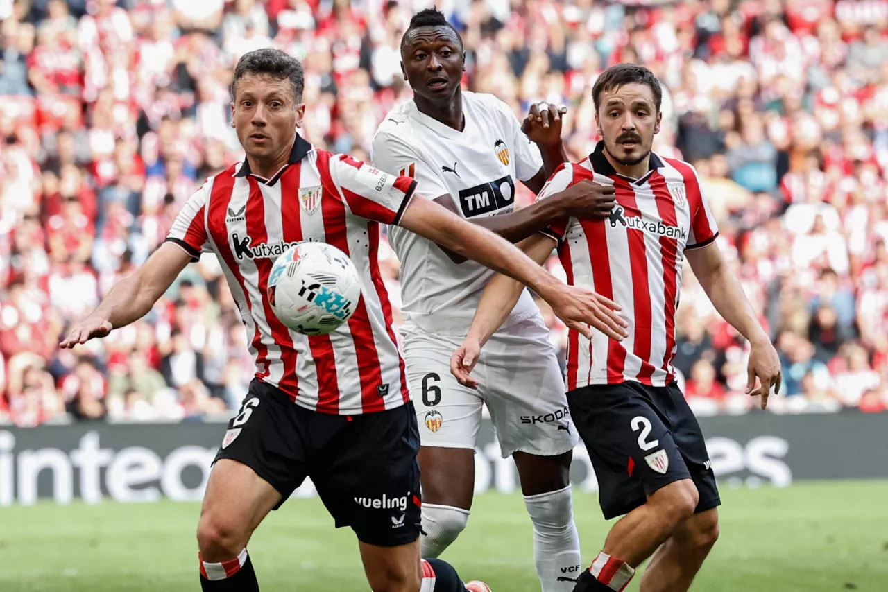 BILBAO, 10/05/2026.- El delantero nigeriano del Valencia Umar Sadiq (c) disputa el balón ante Andoni Gorosabel (d) y Mikel Vesga, ambos del Athletic, durante el partido de Liga disputado este domingo en el estadio de San Mamés, en Bilbao. EFE/Miguel Toña

