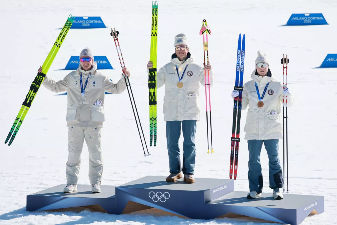 TESERO (Italy), 13/02/2026.- (L-R) Silver medal winner Mathis Desloges of France, gold medal winner Johannes Hoesflot Klaebo of Norway and bronze medal winner Einar Hedegart of Norway react during the award ceremony for the Men's 10km Interval Start Free of the Cross-Country Skiing competitions at the Milano Cortina 2026 Winter Olympic Games, in Tesero, Italy, 13 February 2026. (Francia, Italia, Noruega) EFE/EPA/HANNIBAL HANSCHKE
