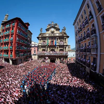 PAMPLONA (ESPAÑA), 06/07/2026.- Vista del ambiente en la Plaza de Ayuntamiento este lunes durante el Chupinazo a cargo de dos representantes de la Subdirección de Urgencias de Navarra con el que da comienzo los Sanfermines 2026, nueve días festivos para los que se han programado más de 500 actos. EFE/Daniel Fernández
