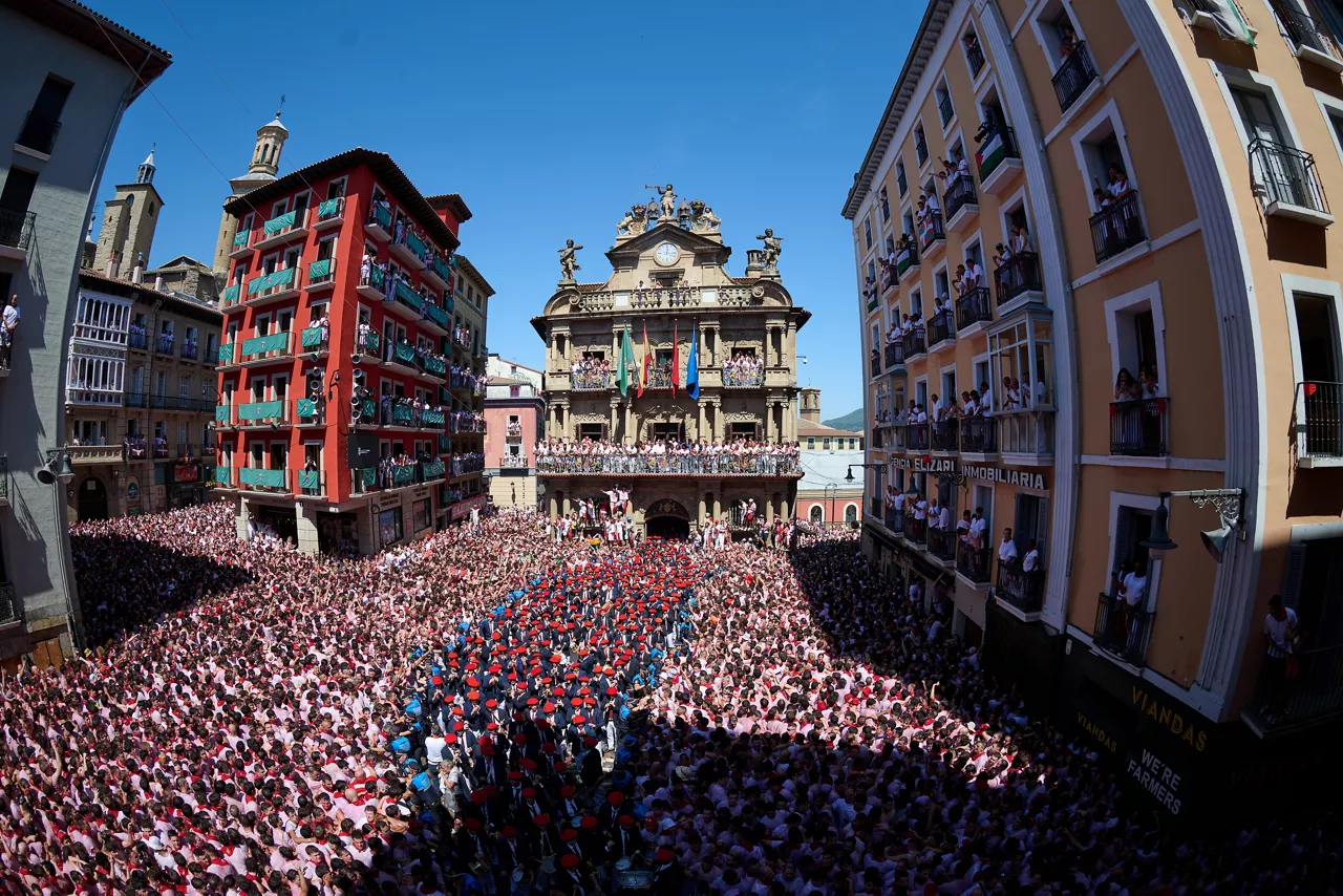 PAMPLONA (ESPAÑA), 06/07/2026.- Vista del ambiente en la Plaza de Ayuntamiento este lunes durante el Chupinazo a cargo de dos representantes de la Subdirección de Urgencias de Navarra con el que da comienzo los Sanfermines 2026, nueve días festivos para los que se han programado más de 500 actos. EFE/Daniel Fernández

