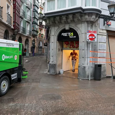 GRAFCAV289. BILBAO, 04/10/2026.-Un camión de limpieza ante un comercio vandalizado tras el caos de las lluvias de la pasada noche, con un total de 150 incidencias por la intensa lluvia en Bizkaia, con numerosas inundaciones y balsas de agua en las carreteras.La alerta naranja da paso a un aviso amarillo que ha finalizado a las 06:00 este domingo.EFE/Luis Tejido
