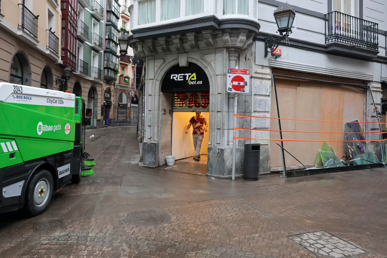 GRAFCAV289. BILBAO, 04/10/2026.-Un camión de limpieza ante un comercio vandalizado tras el caos de las lluvias de la pasada noche, con un total de 150 incidencias por la intensa lluvia en Bizkaia, con numerosas inundaciones y balsas de agua en las carreteras.La alerta naranja da paso a un aviso amarillo que ha finalizado a las 06:00 este domingo.EFE/Luis Tejido
