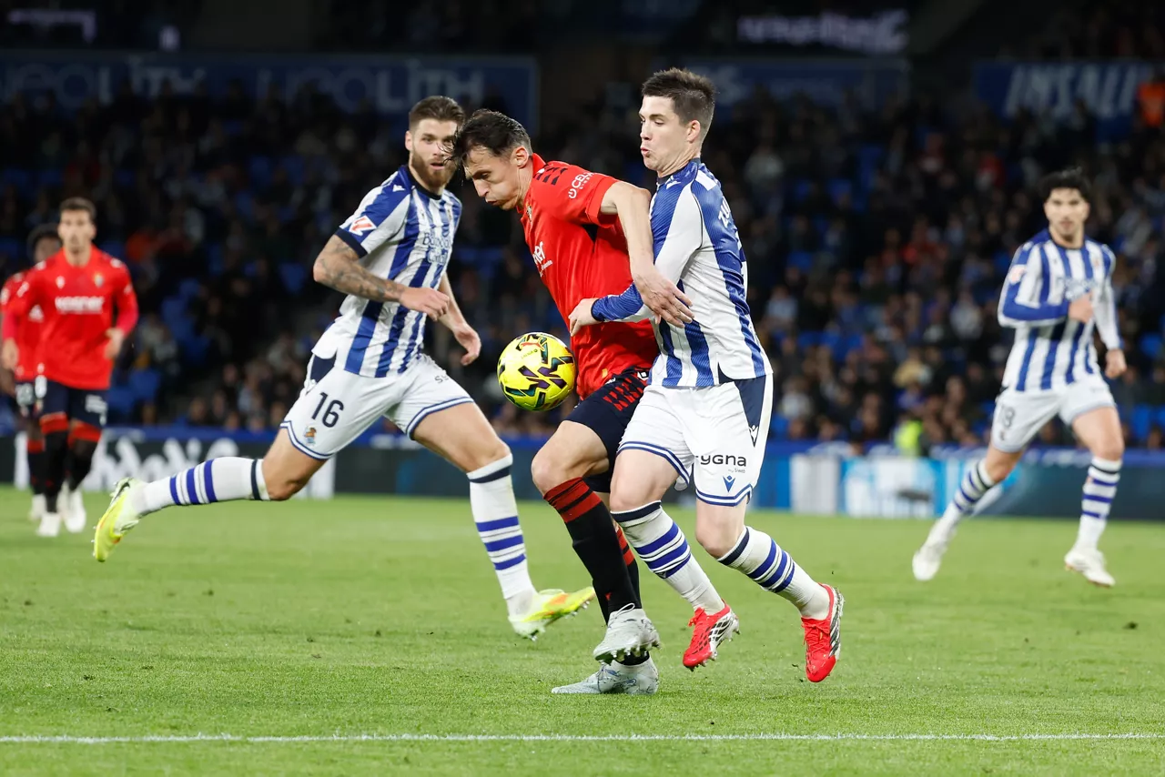 SAN SEBASTIÁN, 15/03/2026.- El delantero croata de Osasuna, Ante Budimir (i), protege el balón ante el defensa de la Real Sociedad, Igor Zubeldia, durante el encuentro correspondiente a la jornada 28 de Laliga EA Sports que disputan este domingo Real Sociedad y Osasuna en el estadio de Anoeta, en San Sebastián. EFE / Juan Herrero.
