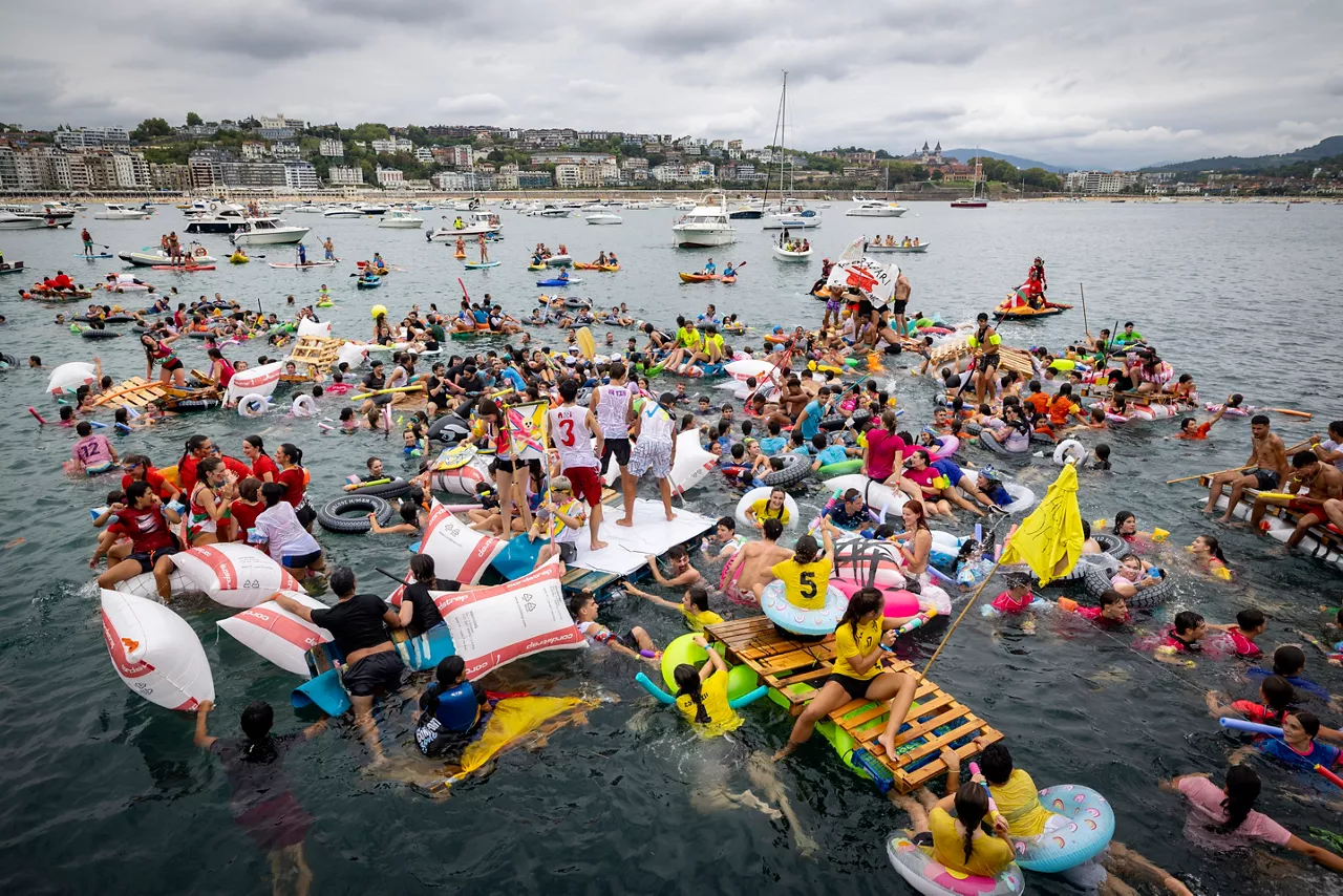 SAN SEBASTIÁN, 10/08/2026.- Cientos de jóvenes han participado este lunes en el tradicional Abordaje de los Piratas, en el tratan de llegar en embarcaciones improvisadas desde el puerto hasta la playa de La Concha, en la tercera jornada de las fiestas de Semana Grande de San Sebastián. EFE/Javier Etxezarreta
