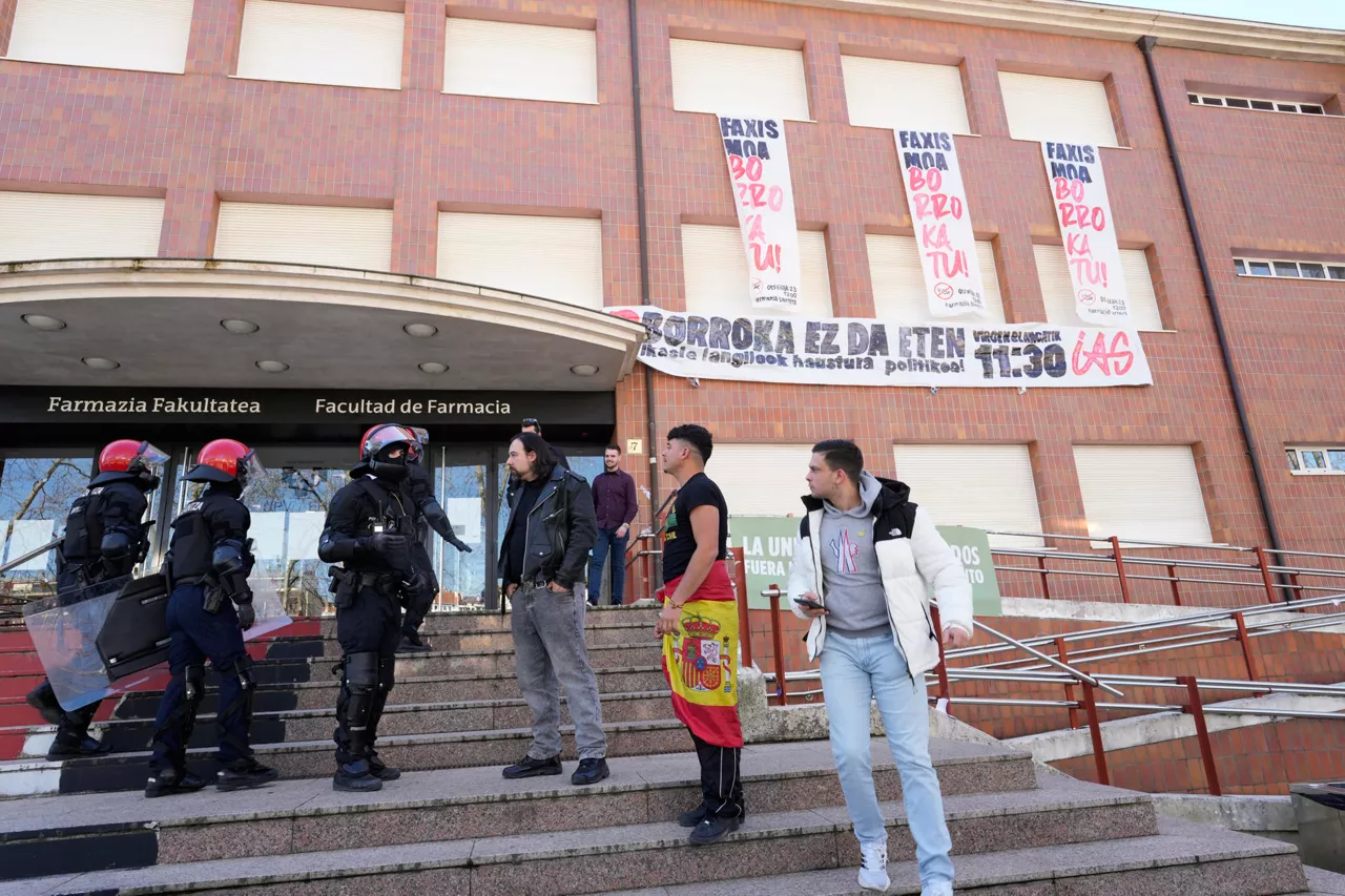 VITORIA, 23/02/2026.- Agentes de la Ertzaintza dan indicaciones a militantes de Vox este lunes en Vitoria durante un acto político de esta formación "en defensa de la liberad en la universidad frente a la izquierda abertzale". La convocatoria de un acto de Vox en el campus alavés de la universidad pública vasca EHU, contra el que grupos de izquierda radical han convocado una contramanifestación, ha derivado en un enfrentamiento político con el rectorado, que ha suspendido las clases para garantizar la seguridad de los alumnos. EFE / ADRIAN RUIZ HIERRO
