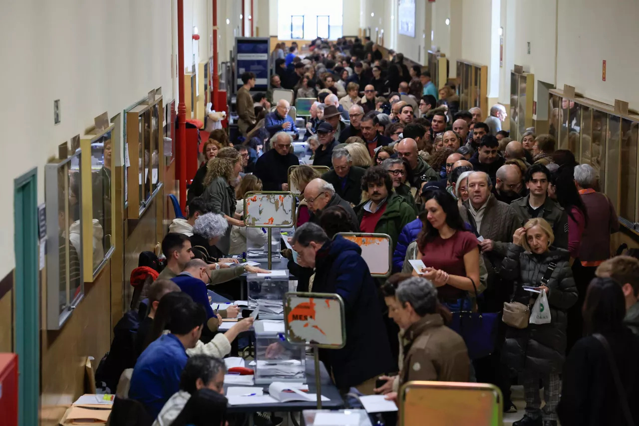 Numerosas personas acuden a votar en un colegio electoral de Zaragoza.