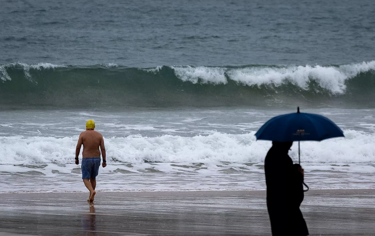 SAN SEBASTIÁN, 24/11/2025.- Un bañista se mete al agua este lunes en la playa de La Concha de San Sebastián a pesar del tiempo adverso. El tiempo previsto para hoy en Euskadi es de cielo muy nuboso o cubierto, precipitaciones débiles que a partir del mediodía aumentarán en intensidad y serán muy abundantes en la vertiente cantábrica, donde habrá también posibilidad de que caigan en forma de tormentas, y cota de nieve que podría bajar a 1.200 metros por la noche. EFE/Javier Etxezarreta
