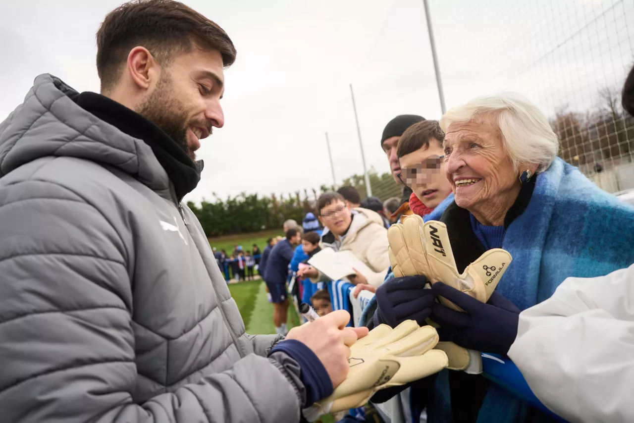 VITORIA, 30/09/2025 .- El portero del Deportivo Alaves, Antonio Sivera, firma sus guantes para regalárselos a una aficionada tras el entrenamiento de puertas abiertas que han celebrado hoy martes. EFE/Adrián Ruiz-Hierro
