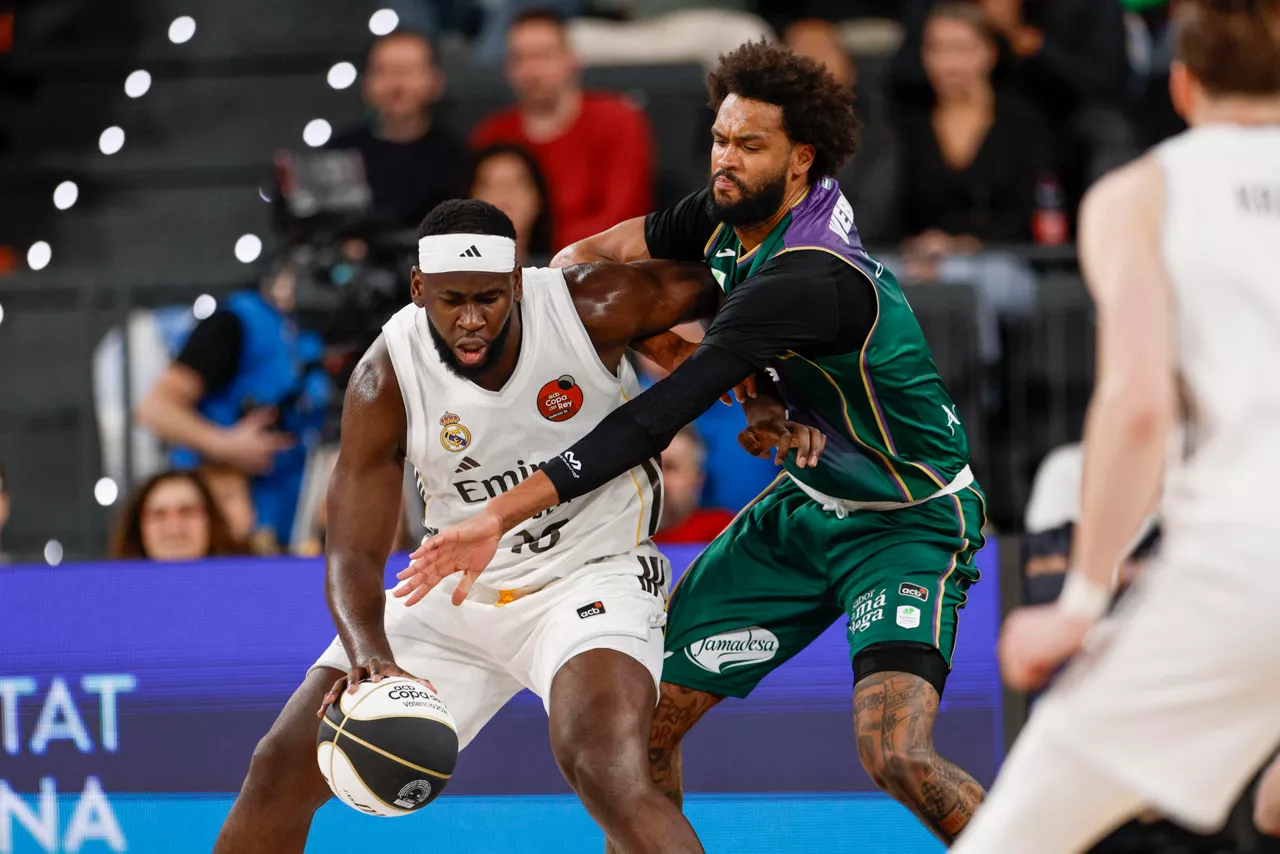 VALENCIA, 19/02/2026.- El pívot del Real Madrid Usman Garuba (i) lucha con James Webb III, de Unicaja Málaga, durante el partido de cuartos de final de la Copa del Rey de baloncesto entre Real Madrid y Unicaja Málaga, este jueves en el Roig Arena, en Valencia. EFE/ Kai Försterling
