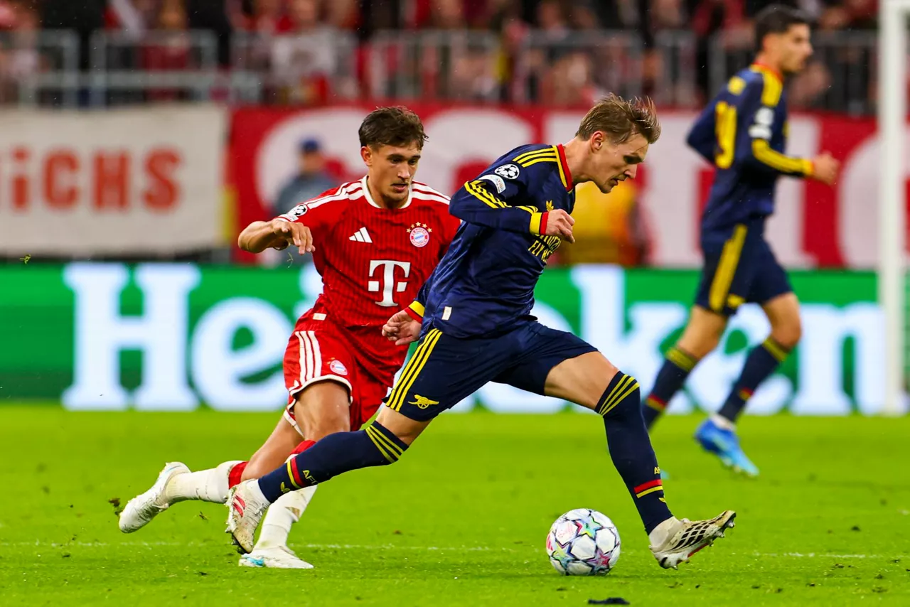 MUNICH (Germany), 21/10/2026.- Tom Bischof of Munich (L) in action against Martin Odegaard of Arsenal (R) during the UEFA Champions League league phase match FC Bayern Munich against Arsenal FC, in Munich, Germany, 21 October 2026. (Liga de Campeones, Alemania) EFE/EPA/ANNA SZILAGYI
