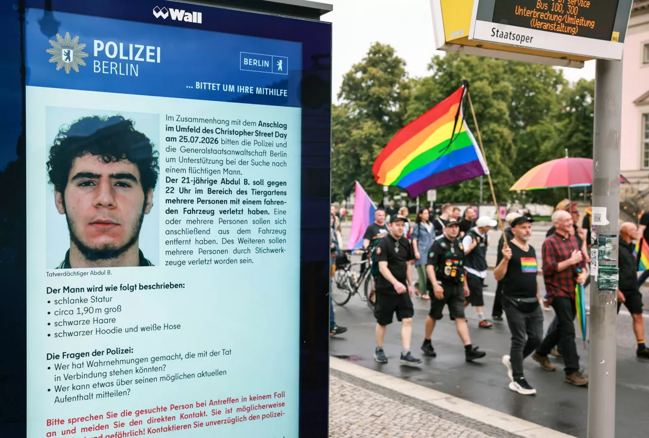 Berlin (Germany), 26/07/2026.- People attending a mourning march following a car-ramming attack near the Christopher Street Day (CSD) parade route pass an electronic display showing a police appeal for information about suspected perpetrator Abdul B. in Berlin, Germany, 26 July 2026. Police said the suspect was believed to be linked to Islamist circles, while German Interior Minister Alexander Dobrindt said the 25 July vehicle ramming, which killed one person and injured 29 others, is being investigated as a terrorist attack. (Terrorista, Atentado terrorista, Alemania) EFE/EPA/CLEMENS BILAN
