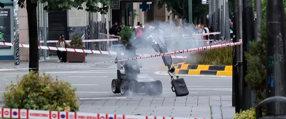 PAMPLONA, 02/05/2026.- Un robot de los artificieros de la Policía Nacional retira la maleta abandonada en una marquesina de una parada de autobús, frente a la sede de la Delegación del Gobierno en Navarra, en la plaza de Merindades de Pamplona, que ha suscitado las sospechas de la Policía y ha obligado a cerrar al tráfico la zona a media mañana de este sábado. EFE/ Villar López
