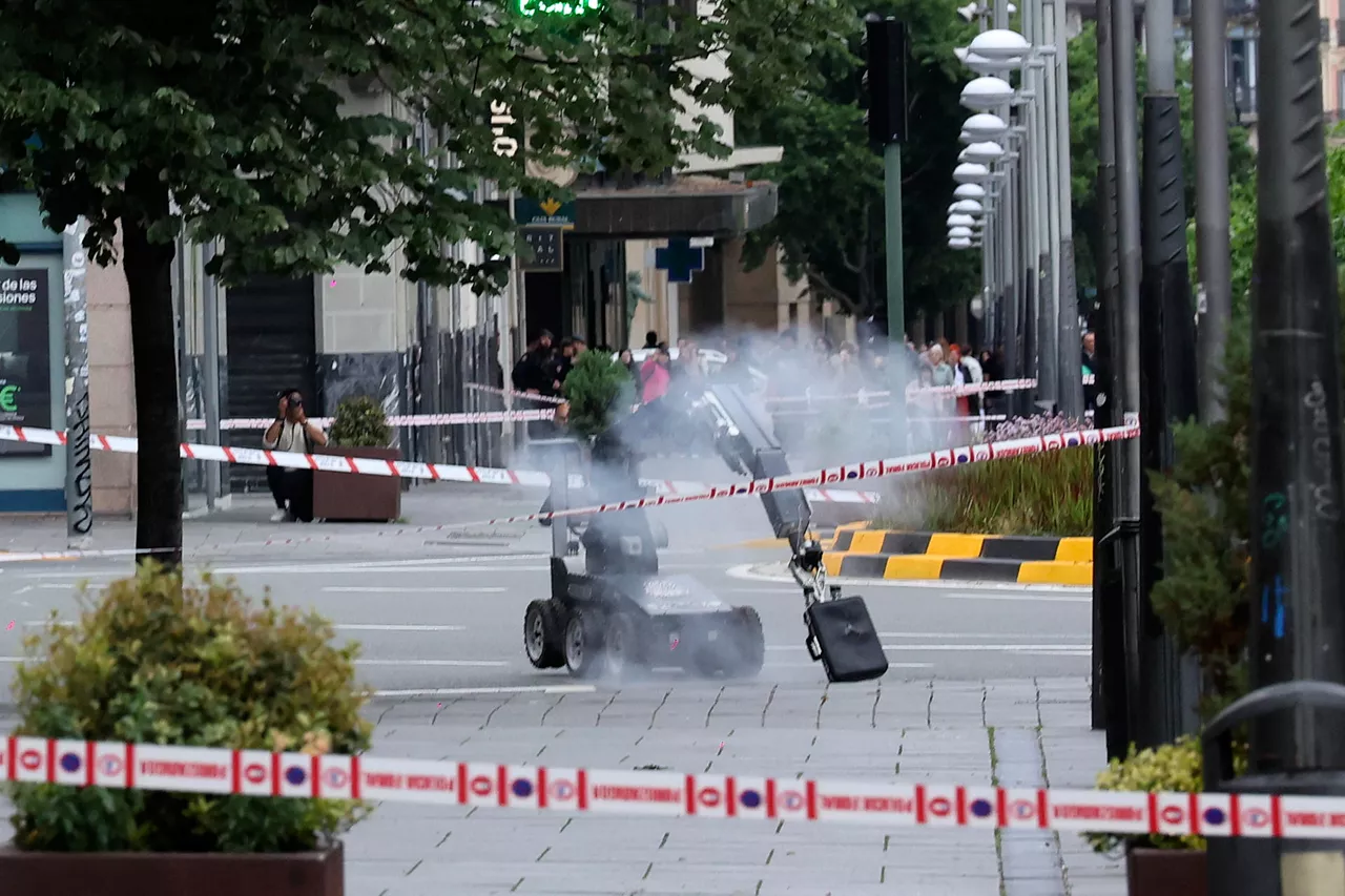 PAMPLONA, 02/05/2026.- Un robot de los artificieros de la Policía Nacional retira la maleta abandonada en una marquesina de una parada de autobús, frente a la sede de la Delegación del Gobierno en Navarra, en la plaza de Merindades de Pamplona, que ha suscitado las sospechas de la Policía y ha obligado a cerrar al tráfico la zona a media mañana de este sábado. EFE/ Villar López
