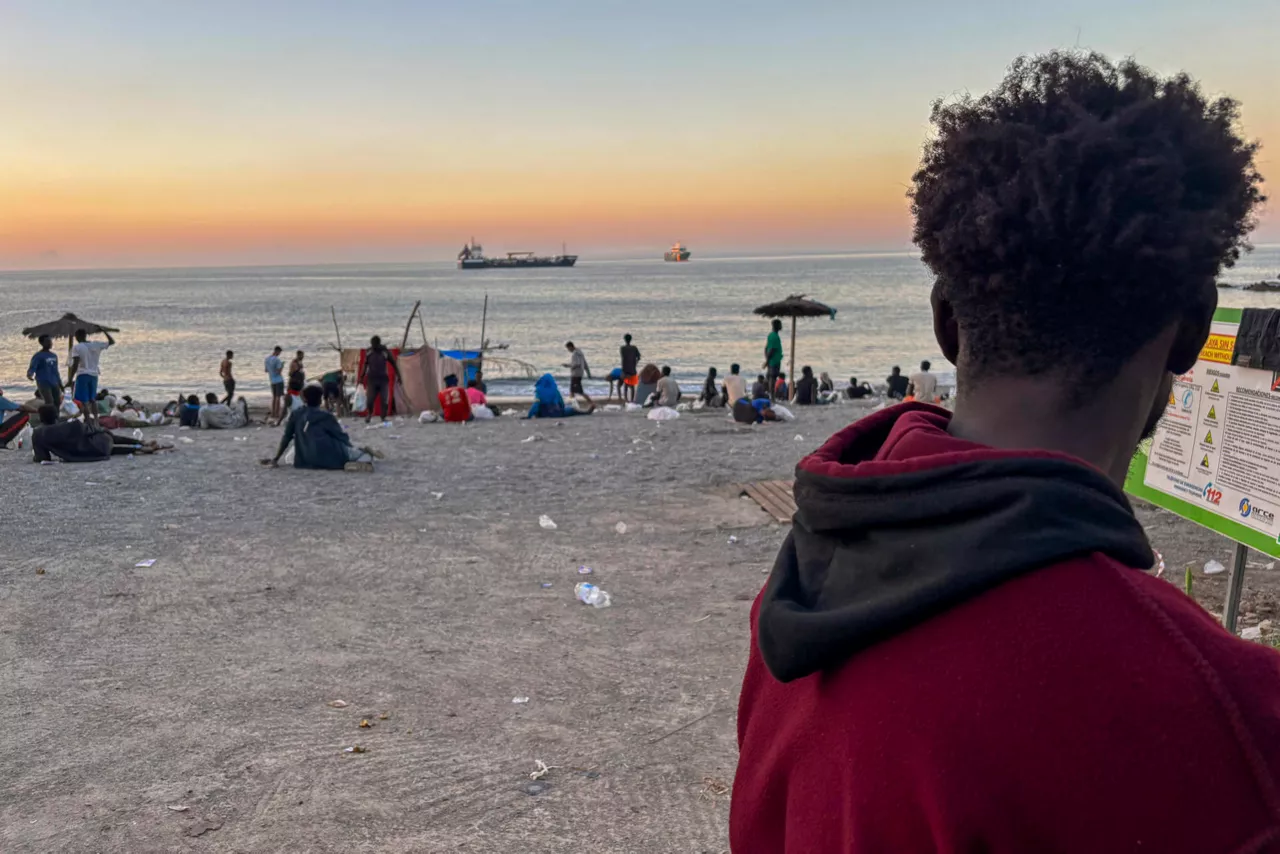 CEUTA (ESPAÑA), 07/08/2026.- Grupos de personas migrantes este viernes, en la playa El trampolín de Ceuta al atardecer, donde muchos se quedan a pasar la noche y hoy han sido atendidos por médicos de la Cruz Roja. EFE/ Laura Rincón
