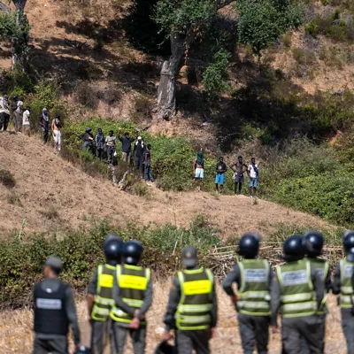 Castillejos (Morocco), 15/08/2026.- Moroccan security forces monitor as they thwart attempts by hundreds of sub-Saharan African and Sudanese migrants who have gathered to enter the Spanish city of Ceuta in Fnideq (Castillejos), Morocco, 15 August 2026. Moroccan security sources report that the incident took place in a mountainous area on the outskirts of Castillejos, southwest of Ceuta. (Marruecos, España) EFE/EPA/JALAL MORCHIDI
