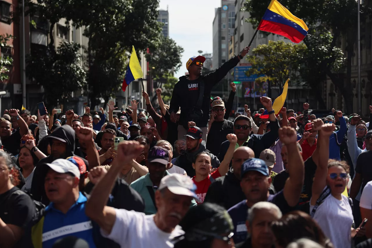 AME1591. CARACAS (VENEZUELA), 03/01/2026.-  Simpatizantes del oficialismo participan en una manifestación en inmediaciones del Palacio de Miraflores este sábado, en Caracas (Venezuela). Chavistas salieron a las calles del centro de Caracas para exigir que "devuelvan" al mandatario venezolano, Nicolás Maduro, luego de que el líder estadounidense, Donald Trump, anunciara la captura del gobernante suramericano en medio de un ataque con misiles durante la madrugada de hoy contra la capital venezolana y otras zonas del país. EFE/ Miguel Gutiérrez
