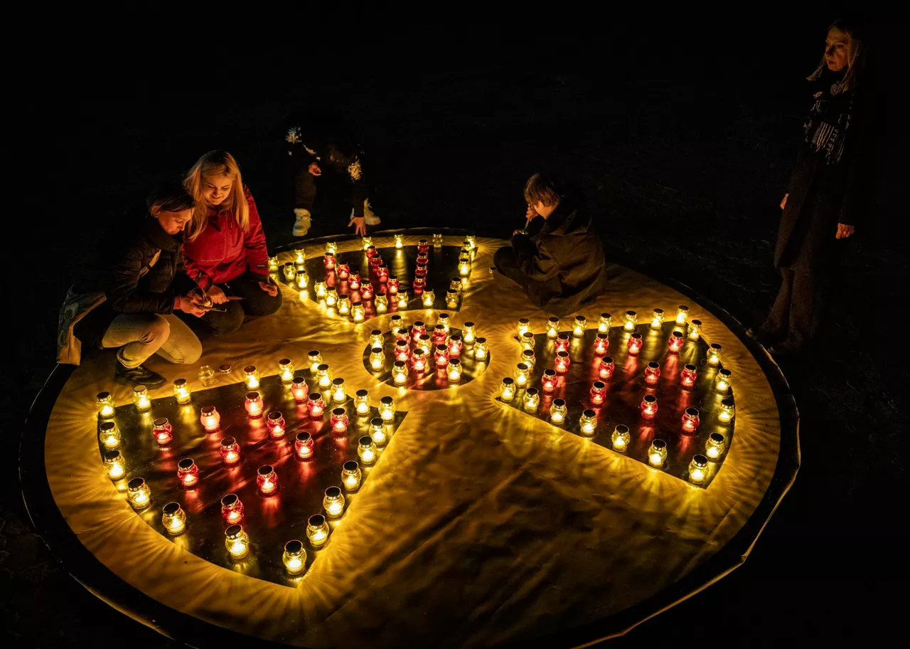 FOTODELDIA SLAVUTYCH, 26/04/2026.- Ucranianos encienden velas colocadas en forma de símbolo de radiación junto aun monumento en memoria de las víctimas en las operaciones de limpieza tras el desastre de la central nuclear de Chernóbil, 26 de abril de 2026. EFE/MAKSYM KISHKA 115664

