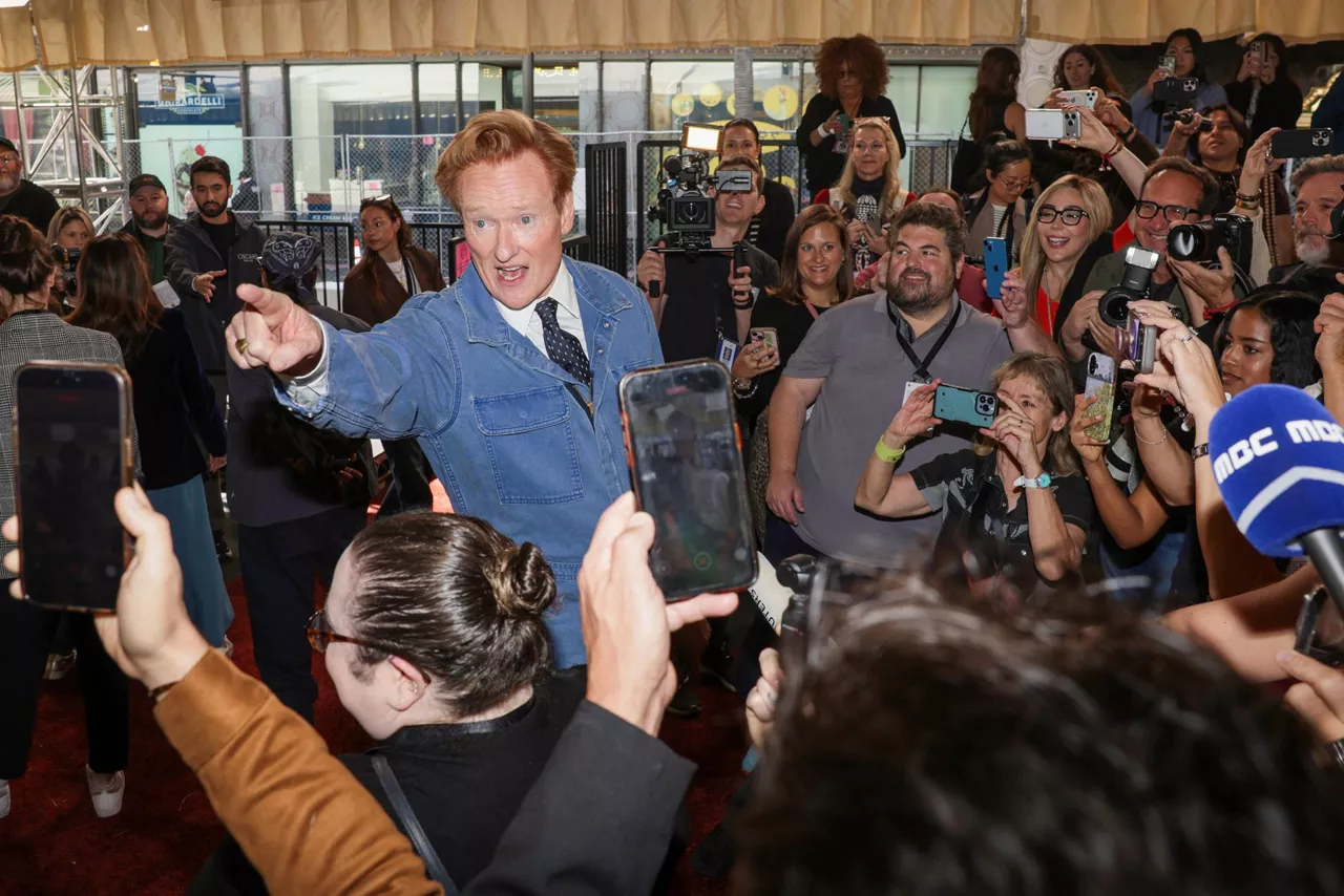 LOS ANGELES (United States), 11/03/2026.- Oscars host Conan O'Brien (C) speaks to the media after rolling out the red carpet for the 98th annual Academy Awards ceremony at the Dolby Theatre at Ovation Hollywood in Los Angeles, California, USA, 11 March 2026. The Oscars will be presented for outstanding individual or collective efforts in filmmaking on 15 March 2026. EFE/EPA/CHRIS TORRES
