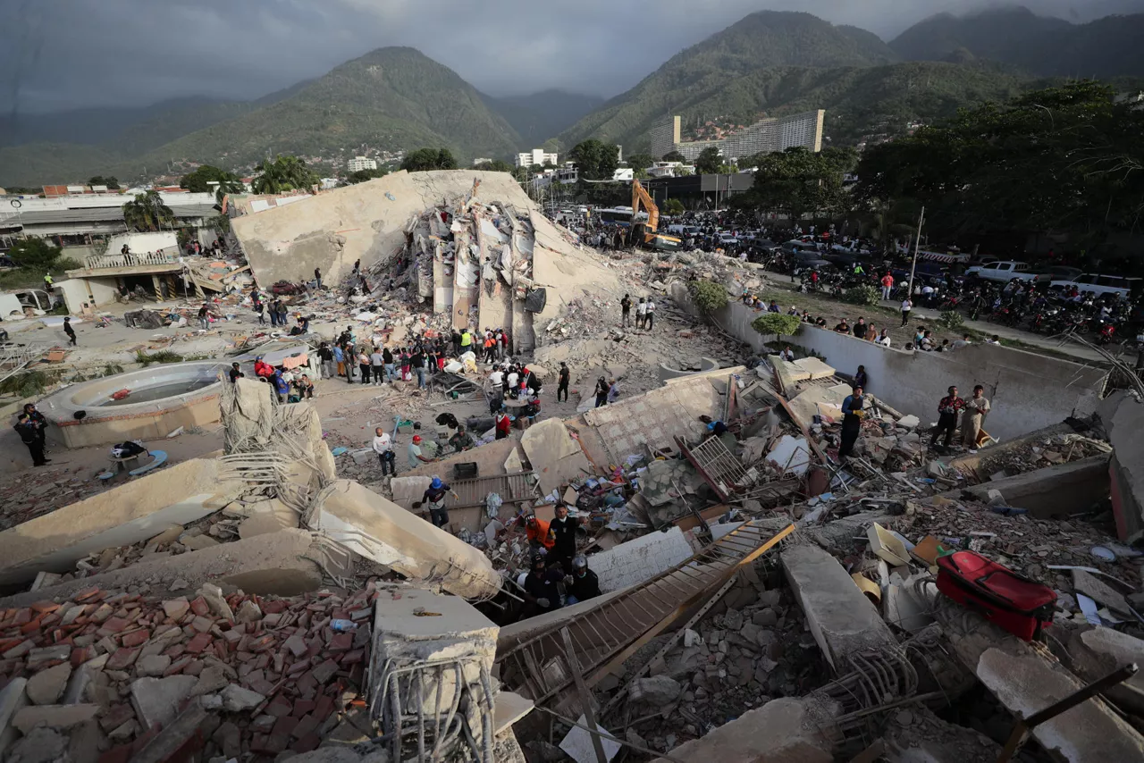 AME5030. LA GUAIRA (VENEZUELA), 26/06/2026.- Personas realizan labores de búsqueda en una zona afectada por un terremoto este viernes, en La Guaira (Venezuela). El ministro de Interior de Venezuela, Diosdado Cabello, anunció la restricción del acceso al estado La Guaira (norte, cercano a Caracas), el más afectado por los terremotos, a partir de las 20.00 horas locales (00.00 GMT) de este viernes. EFE/ Ronald Peña R
