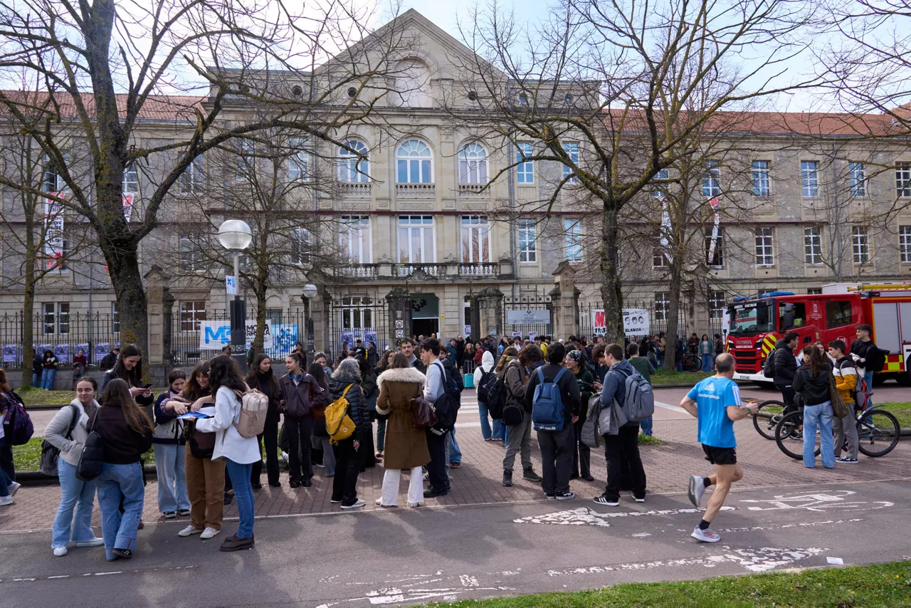 VITORIA, 02/03/2026.- Alumnos tras ser desalojados este lunes del campus de la Universidad del País Vasco (EHU) en Vitoria por los servicios de emergencia tras el lanzamiento en su interior de botes de humo, se han visto afectados cinco edificios del campus de la EHU. EFE / L. Rico
