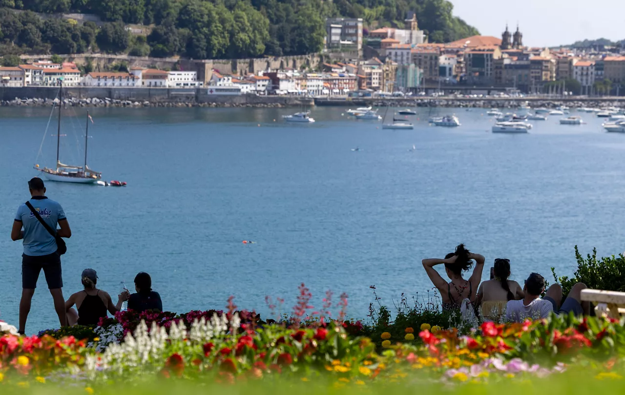 SAN SEBASTIÁN, 24/06/2026.- Varias personas descansan a la sombra junto a la bahía de La Concha de San Sebastián este miércoles, en el que la Agencia Estatal de Meteorología ha hecho un balance del tiempo que ha hecho en primavera en el País Vasco y expone el pronóstico de la Aemet para este verano. EFE/Javier Etxezarreta
