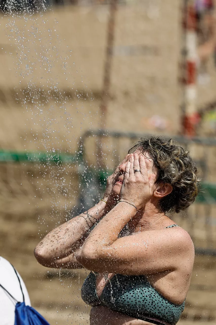 GETXO (BIZKAIA), 21/06/2026.- Una mujer se refresca en una ducha en la playa de Ereaga en Getxo (Bizkaia) este domingo, jornada en la que el Departamento vasco de Seguridad ha elevado la alerta a roja por la ola de calor al esperarse temperaturas muy altas que alcancen los 40 grados.  EFE/ Miguel Toña
