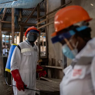 Bunia (Congo, The Democratic Republic Of The), 23/05/2026.- Sanitation workers wearing protective gear disinfect market stalls at a wet market in Bunia, Ituri province, Democratic Republic of the Congo, 23 May 2026, as part of containment measures to halt the spread of the Ebola virus. The World Health Organization (WHO) recently raised the national risk level to 'very high' following a surge in cases. The outbreak, officially declared by the DRC Ministry of Health on 15 May, is driven by the Bundibugyo strain of the virus, for which there are currently no approved vaccines or specific therapeutic treatments. EFE/EPA/STRINGER
