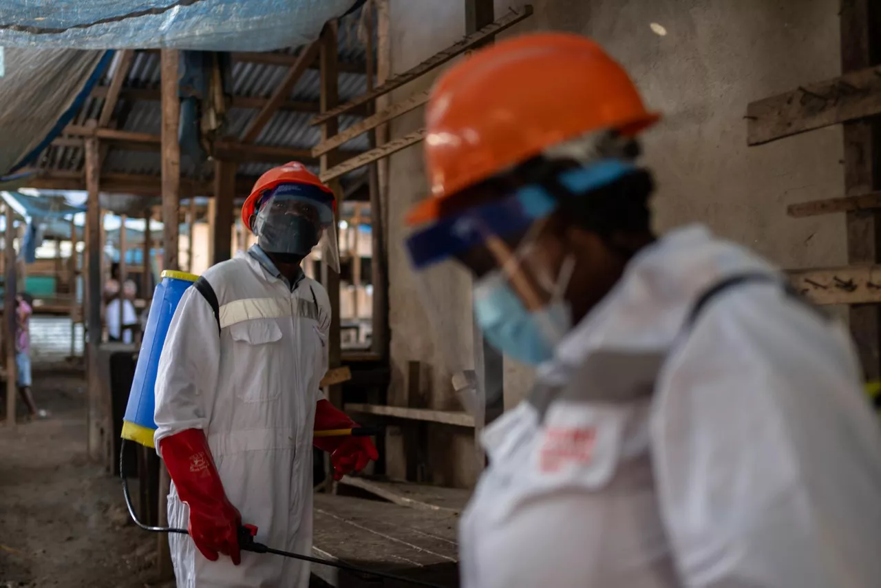 Bunia (Congo, The Democratic Republic Of The), 23/05/2026.- Sanitation workers wearing protective gear disinfect market stalls at a wet market in Bunia, Ituri province, Democratic Republic of the Congo, 23 May 2026, as part of containment measures to halt the spread of the Ebola virus. The World Health Organization (WHO) recently raised the national risk level to 'very high' following a surge in cases. The outbreak, officially declared by the DRC Ministry of Health on 15 May, is driven by the Bundibugyo strain of the virus, for which there are currently no approved vaccines or specific therapeutic treatments. EFE/EPA/STRINGER
