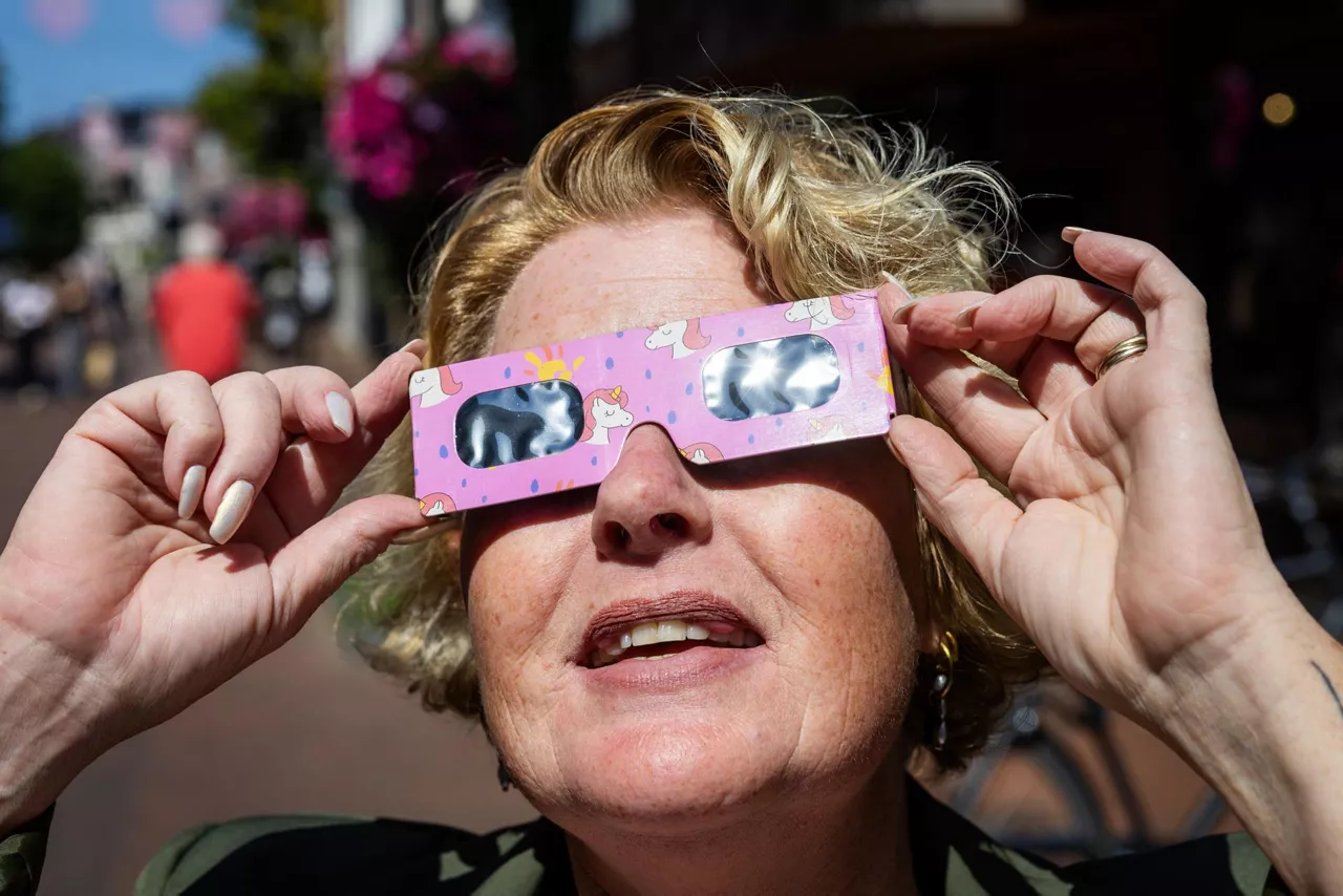 ALMELO (Netherlands), 11/08/2026.- A woman wears eclipse glasses in Almelo, the Netherlands, 11 August 2026. The sun will soon be almost completely eclipsed, an event that occurs infrequently in the Netherlands. (Países Bajos; Holanda) EFE/EPA/VINCENT JANNINK
