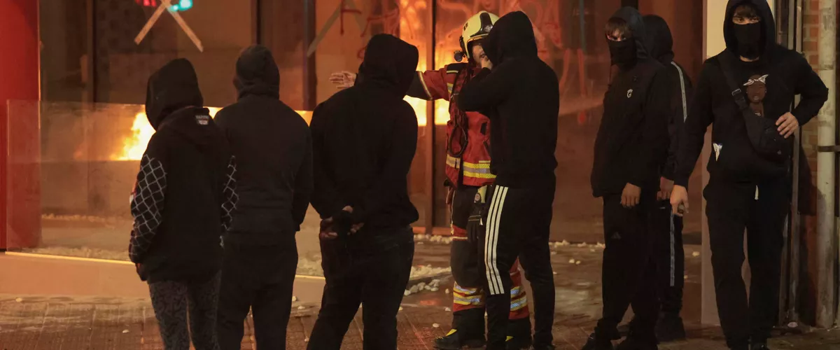 BILBAO, 26/10/2026.- Un bombero habla con un grupo de asistentes a la manifestación de estudiantes y de colectivos 'antifascistas' este lunes por el centro de Bilbao "contra el fascismo" y en protesta por el acto anunciado por el agitador y activista político Vito Quiles para esta tarde en la ciudad. EFE/Luis Tejido
