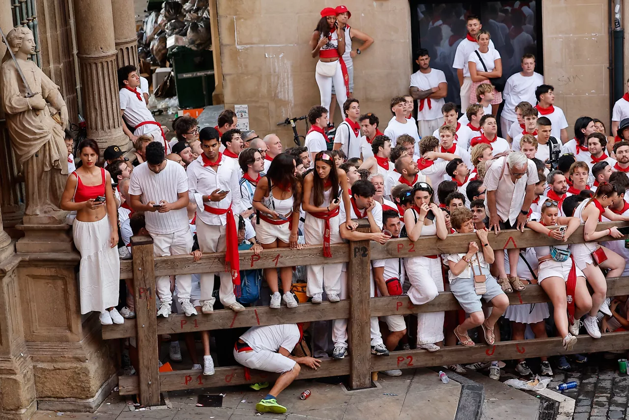 PAMPLONA, 07/07/2026.- Espectadores siguen el primer encierro de los Sanfermines 2026, protagonizado por toros de la ganadería gaditana de Fuente Ymbro, desde la Plaza Consistorial, este martes en Pamplona. EFE/Villar López
