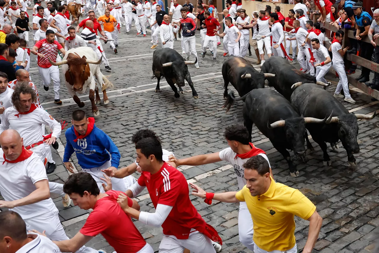 PAMPLONA, 13/07/2026.- Los toros de la ganadería sevillana de Miura entran en la curva de Mercaderes durante el séptimo encierro de los Sanfermines 2026, este lunes en Pamplona. EFE/Jesús Diges
